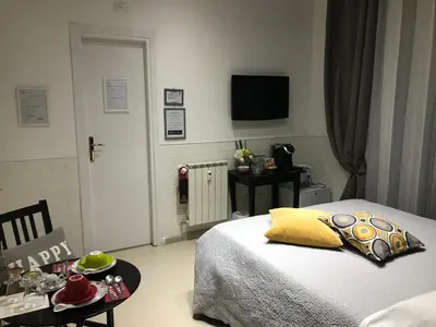 a bedroom with a bed and a table and a television at Vatican City Holidays Guesthouse in Rome