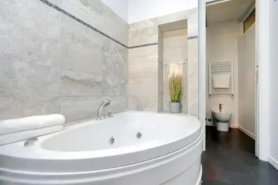 a white bath tub in a bathroom with a toilet at Monti charming apartment - Rome short let Service in Rome