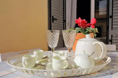 a table with a plate with tea cups and glasses at Monti charming apartment - Rome short let Service in Rome