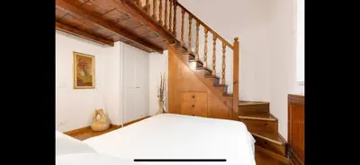 a bedroom with a white bed and a staircase at IN FRONT OF COLISEUM 2 in Rome