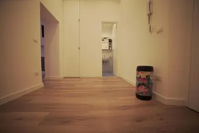 an empty room with a wooden floor and a hallway at Arcadia apartments in Rome