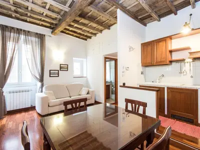 a kitchen and living room with a table and a couch at Apartment Domus Fori by Interhome in Rome
