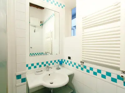 a white bathroom with a sink and a mirror at Apartment Vittorio Emanuele-1 by Interhome in Rome