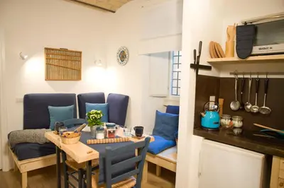 a small dining room with a table and blue chairs at Private Modern Studio Paolina City Center in Rome