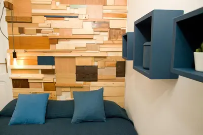 a living room with a wall made of wood at Private Modern Studio Paolina City Center in Rome