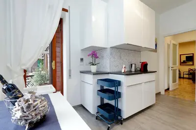a kitchen with white cabinets and a blue cart at YCH-TRASTEVERE cozy flat for 8 people in Rome