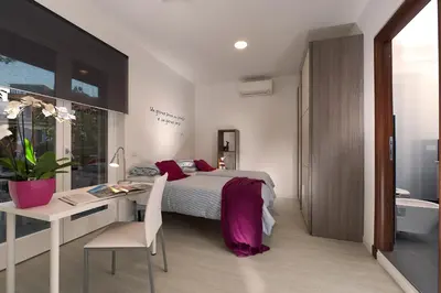 a bedroom with a bed and a desk and a bathroom at Vatican Meadows in Rome