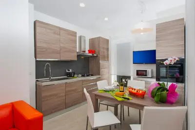 a kitchen with a wooden table with chairs and a dining room at Vatican Meadows in Rome