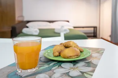 a table with a glass of orange juice and a plate of food at Vatican Apartment Borgo Pio in Rome