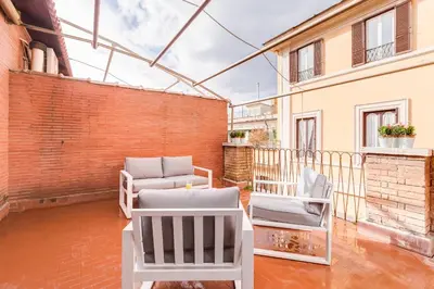 a patio with chairs and tables and a brick wall at Trevi area Penthouse in Rome
