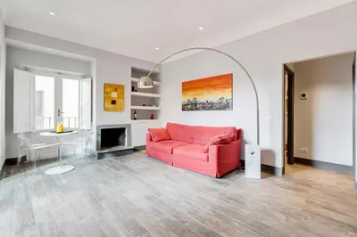 a living room with a pink couch and a table at Trevi area Penthouse in Rome