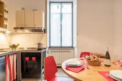 a kitchen with a table with red chairs and an oven at Elizabeth House - WelcomeToRhome in Rome