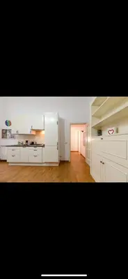 a large kitchen with white cabinets and wooden floors at IN FRONT OF COLISEUM 3 in Rome