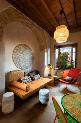 a living room with a couch and a table and chairs at Palm Suites - Small Luxury Hotels of the World in Rome