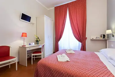a bedroom with a bed with a desk and a red blanket at Ottaviano Guest House in Rome
