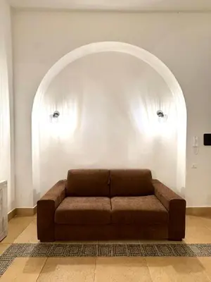 a couch in a living room with an archway at Exclusive Central Apartment 48 in Rome