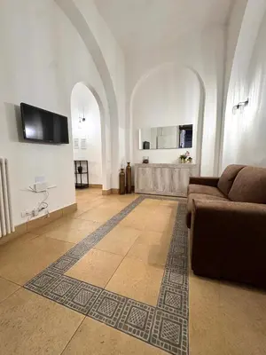 a living room with a couch and a tv on a wall at Exclusive Central Apartment 48 in Rome