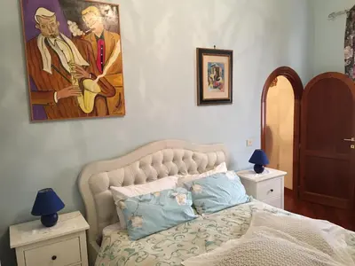 a bedroom with a bed and a painting on the wall at A CASA DI ZIA LOLA in Rome