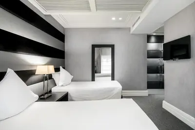 a hotel room with two beds and a television at Hotel Mancino 12 in Rome