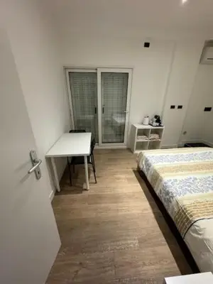 a bedroom with two beds and a table and a desk at Alloggio Roma Appia in Rome