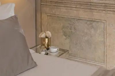 a bed with a nightstand with a cup and a clock at Navona Style in Rome