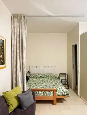a bedroom with a bed and a couch at Studio Flat Vaticano in Rome