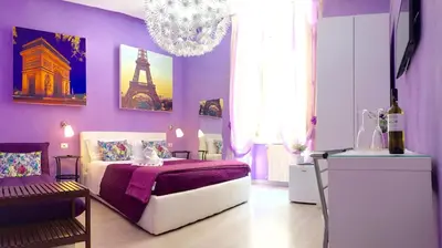 a purple bedroom with a bed and a chandelier at CityLife Rome in Rome