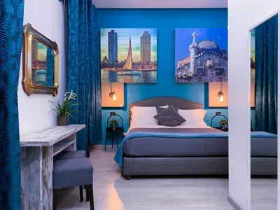 a bedroom with blue walls and a bed and a table at CityLife Rome in Rome