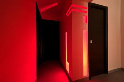 a room with a red wall and two open doors at Roma Naif Rooms in Rome
