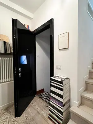 a black door in a room with a stack of dvds at Art Lover's Loft in Rome