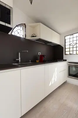 a kitchen with white cabinets and a sink at Art Lover's Loft in Rome