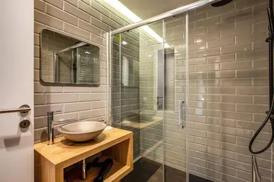 a bathroom with a sink and a glass shower at Sant'Eligio 2BDR in Rome