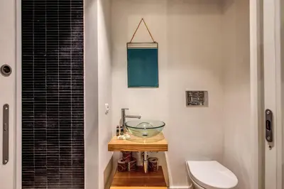 a bathroom with a bowl sink on a table next to a toilet at Sant'Eligio 2BDR in Rome