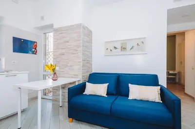 a living room with a blue couch and a white table at Ottoboni Apartment, 4 persone, balcone, Wi-Fi, Stazione Tiburtina in Rome