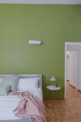 a bedroom with a green wall and a bed with a table at Giglio quiet apartment at Campo dei Fiori in Rome