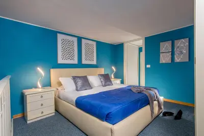 a blue bedroom with a bed and two lamps at Navona Blue Apartment in Rome