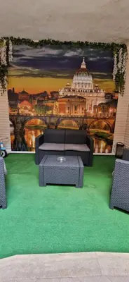 a room with a mural of a building with a table and chairs at Oasi Del Vaticano in Rome