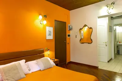an orange bedroom with a bed and a mirror at GREGORIANA HOUSE - Appartamento con Vista su Roma in Rome