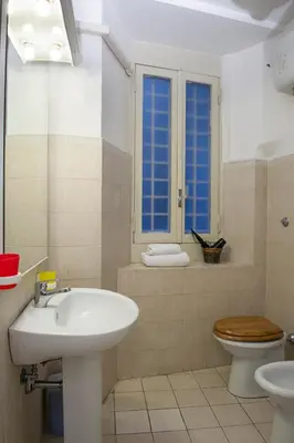 a bathroom with a sink and a toilet at GREGORIANA HOUSE - Appartamento con Vista su Roma in Rome