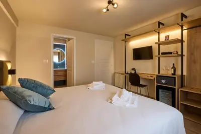 a bedroom with a large white bed with blue pillows at Relais Tiburtina in Rome