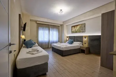 a hotel room with two beds and a window at Relais Tiburtina in Rome