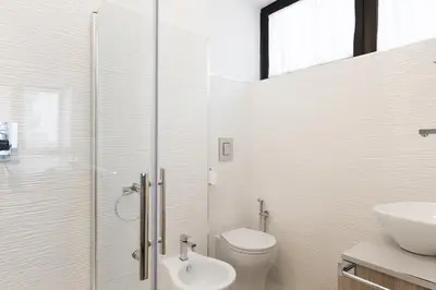 a white bathroom with a toilet and a sink at Casette Romane 