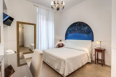 a bedroom with a bed and a mirror and a table at Bless&B G.H. in Rome