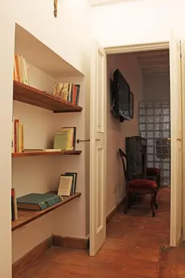 a hallway with a book shelf and a tv on a wall at Monti Bespoke in Rome