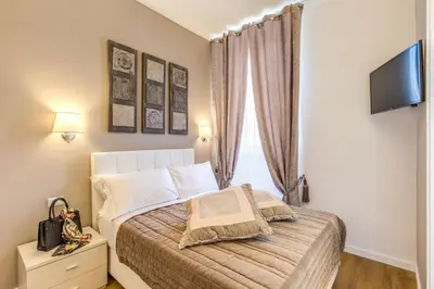 a bedroom with a bed with a television on the wall at The Bridge Suites in Rome