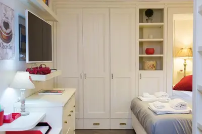 a bedroom with a bed and a desk with towels at Pantheon Romantic Loft in Rome