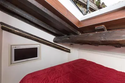 a bedroom with a red bed and a tv at Pantheon Romantic Loft in Rome