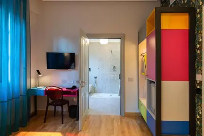 a room with a desk and a bathroom with a shower at Albergo Etico Roma in Rome
