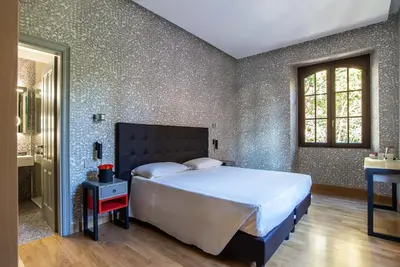 a bedroom with a large bed and a window at Albergo Etico Roma in Rome