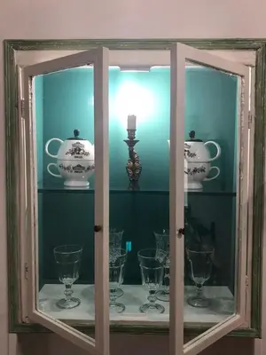 a glass cabinet with a bunch of cups and dishes at 